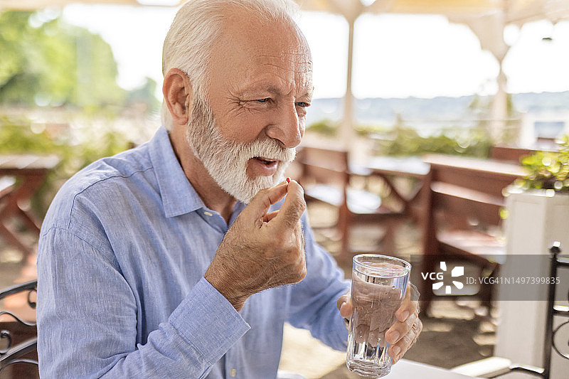 正在服药的微笑老人图片素材