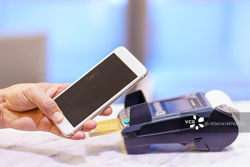 在商店使用非接触式支付的女人图片素材