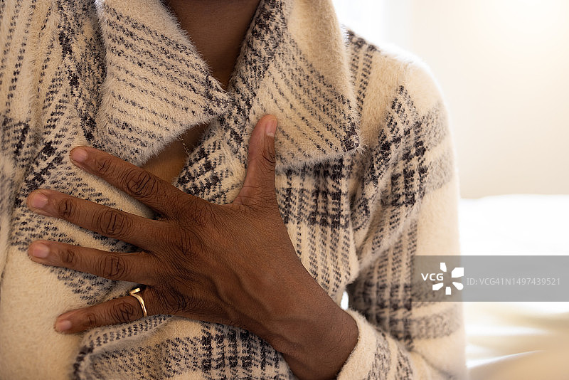 黑人女性坐在沙发上感到胸痛图片素材