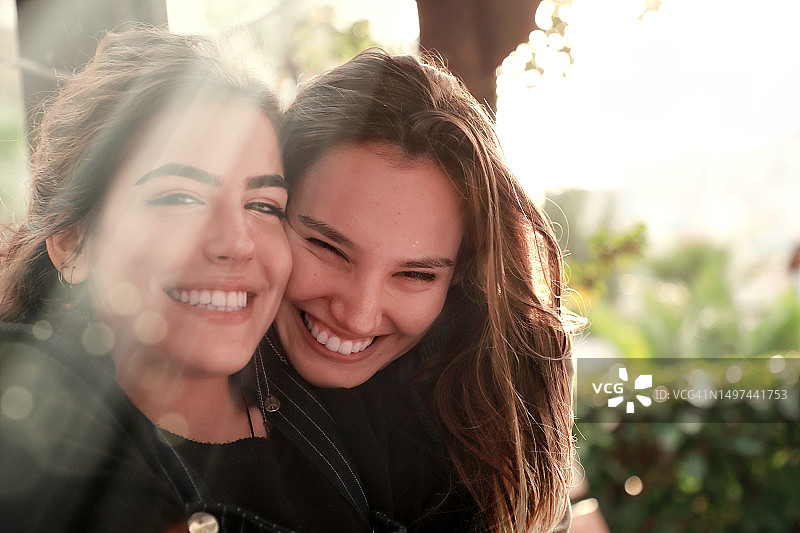 户外：阳光明媚的日子里，公园里两个快乐的深色头发年轻女人图片素材