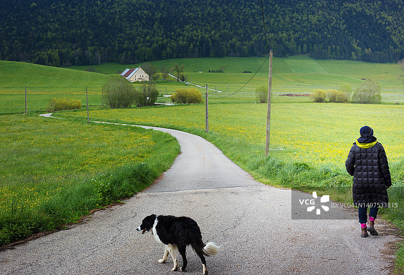 春天在法国韦科尔与狗散步的女人图片素材