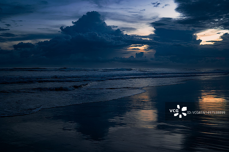 热带海滩黄昏时分乌云密布的壮丽天空图片素材