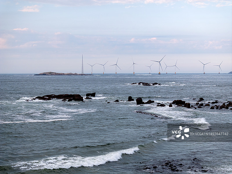 涨潮的海面，远处的海上风电场图片素材