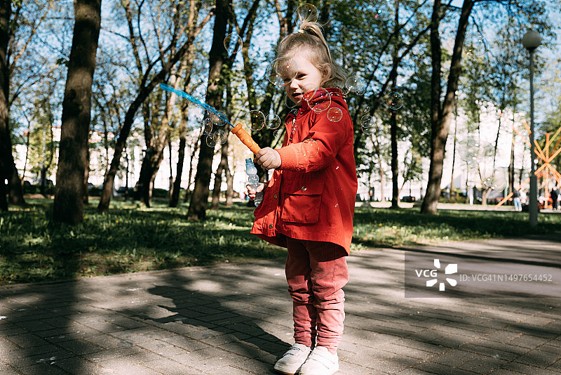 穿红色外套吹泡泡的女孩图片素材
