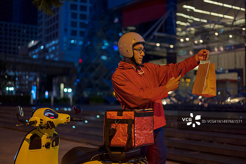 快递员用手机拍照记录送餐过程图片素材