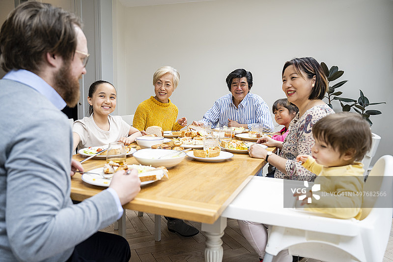 家庭成员在餐桌旁听男人讲话图片素材