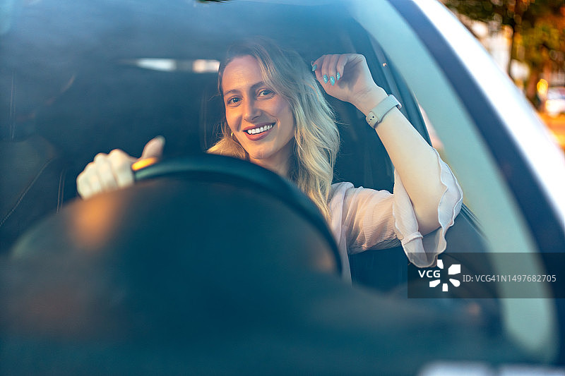 快乐的金发女子开车图片素材
