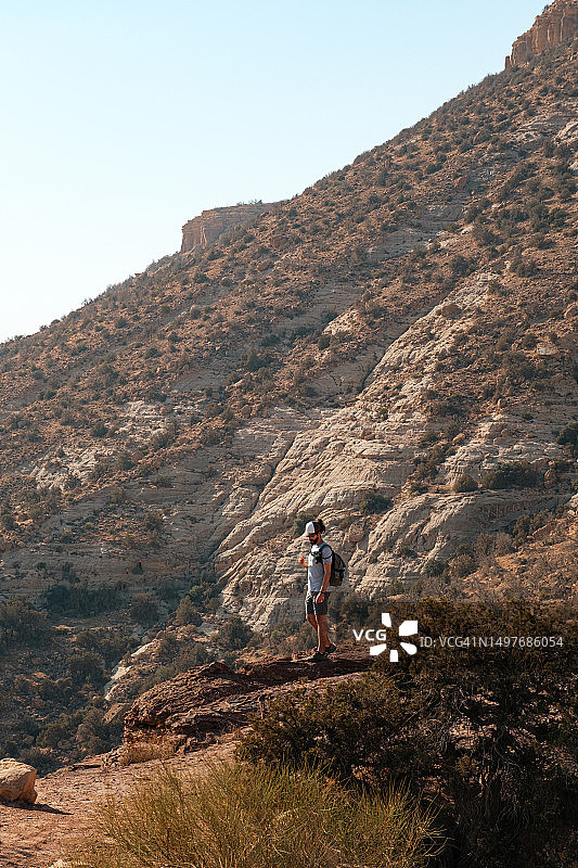戴着帽子走在达纳自然保护区约旦山脉中的男人图片素材