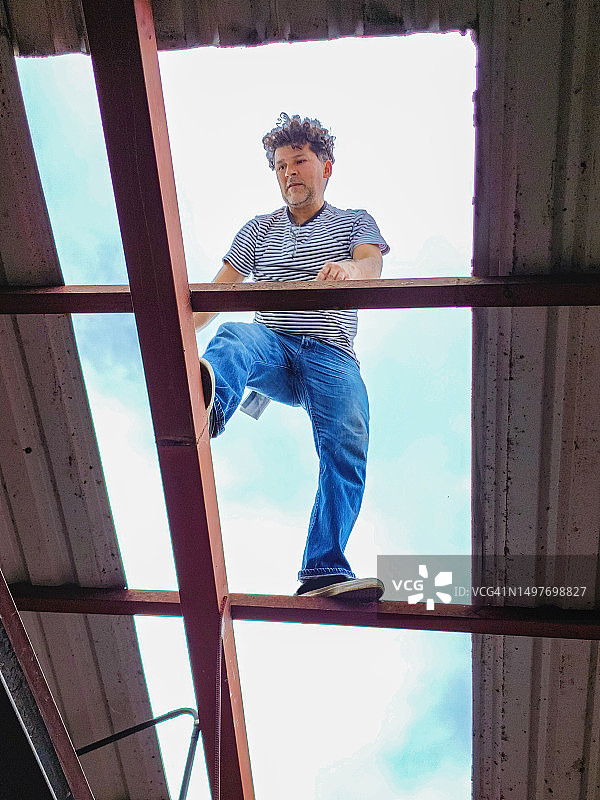 男人仰视修理屋顶图片素材