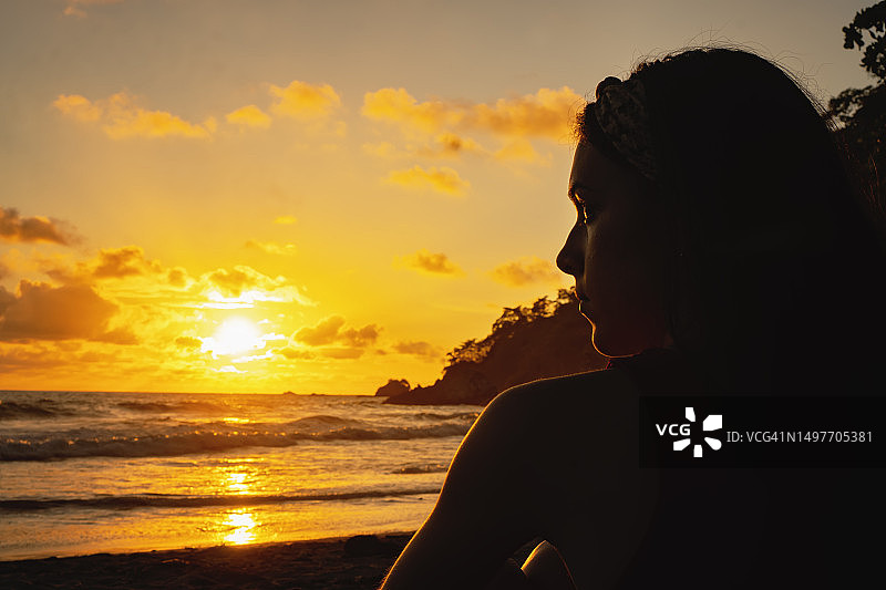 哥斯达黎加热带海滩上，在温暖日落前的年轻女子图片素材