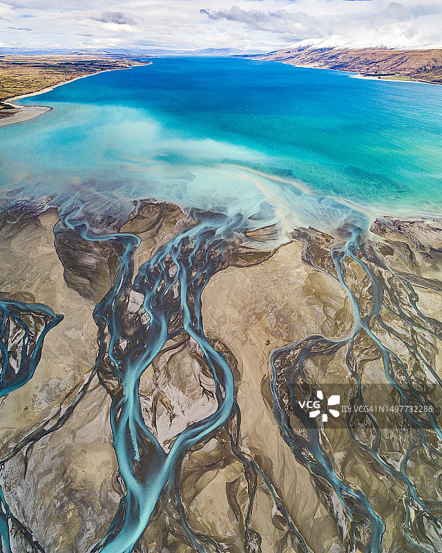 冰川径流形成的河流辫状系统，碧绿的湖泊和白雪皑皑的山脉航拍视角图片素材