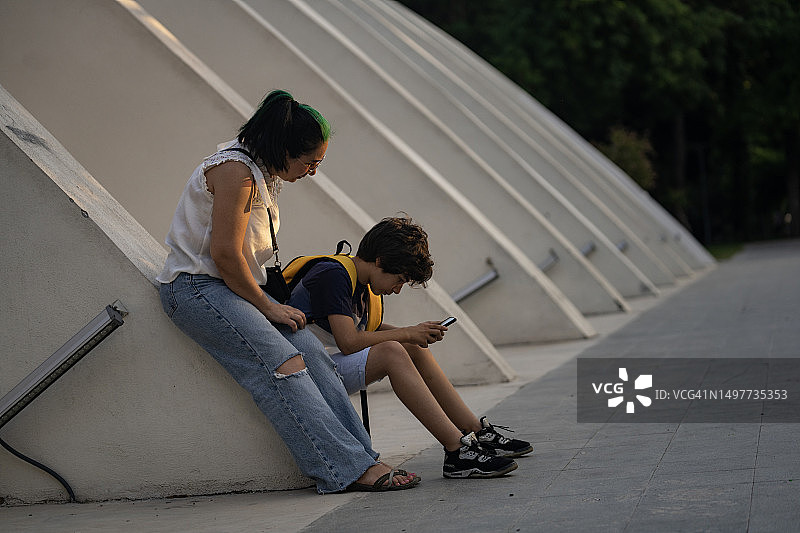 户外，母亲和儿子使用智能手机照片图片素材