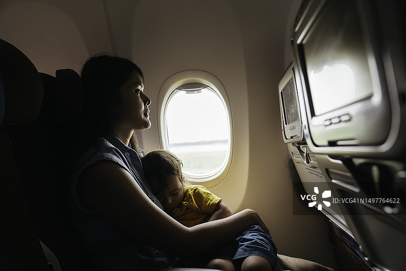 母亲在飞机上抱着儿子图片素材