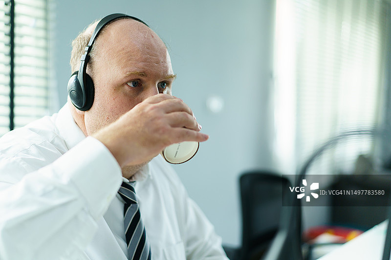 年长白人商人在办公室工作。图片素材