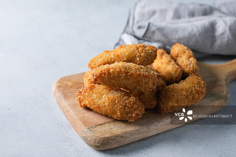 淡蓝色桌子上的番茄酱鸡块图片素材