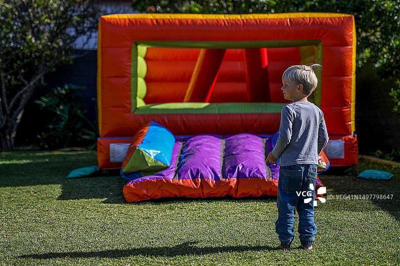 小男孩在充气城堡上玩耍庆祝生日图片素材