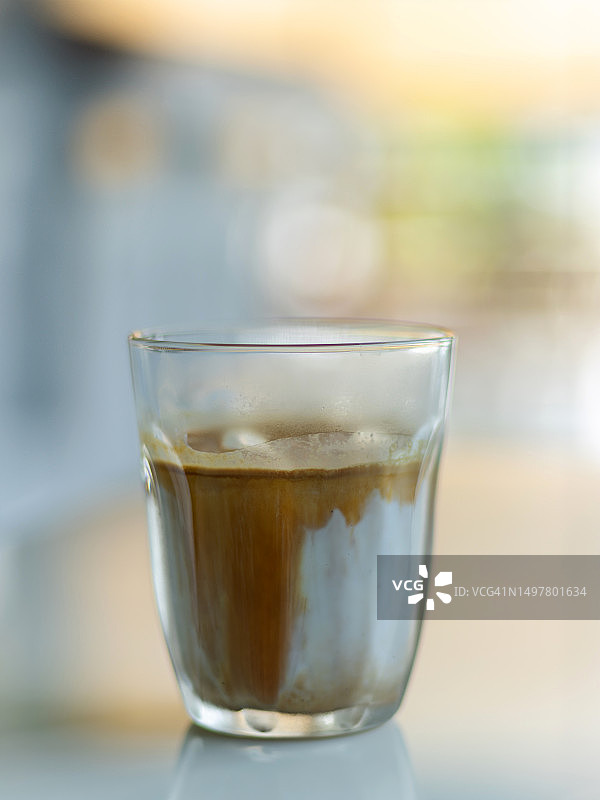 一杯浓缩咖啡与冰鲜牛奶混合饮品图片素材