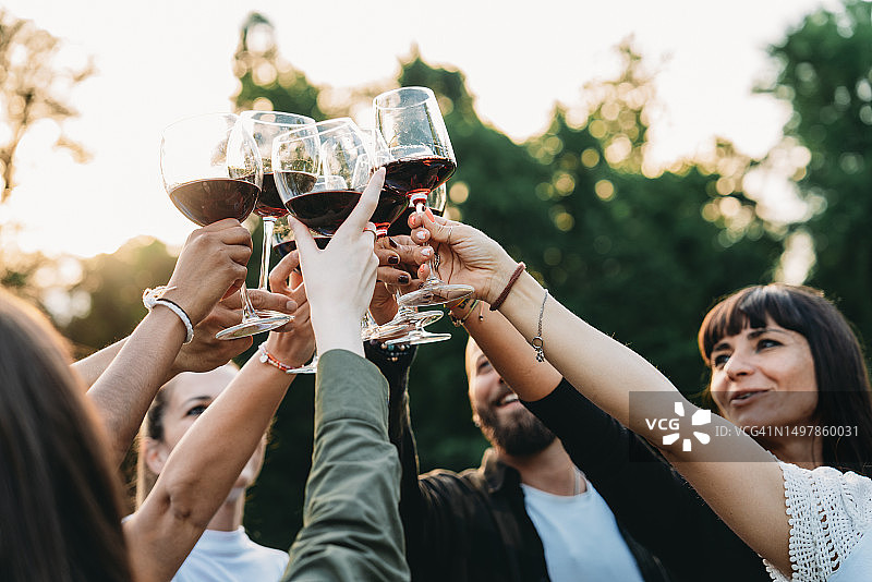 一群朋友在户外日落时分举杯红酒祝酒图片素材
