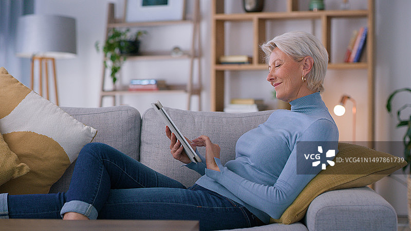 女人，在家中或客厅里放松或在平板电脑上阅读电子书：用于想法、时间表或章节管理。拥有互联网博客、故事和流媒体的中年人图片素材