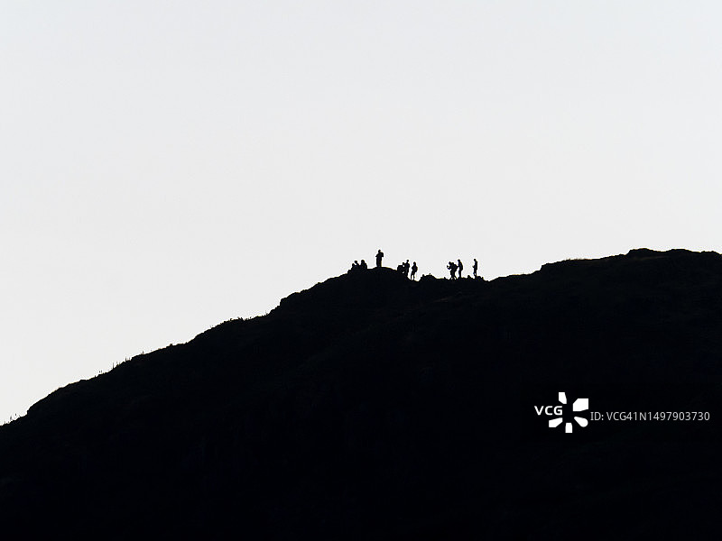 在英国湖区安布尔赛德的托德山顶上，一群青少年在黄昏时分图片素材