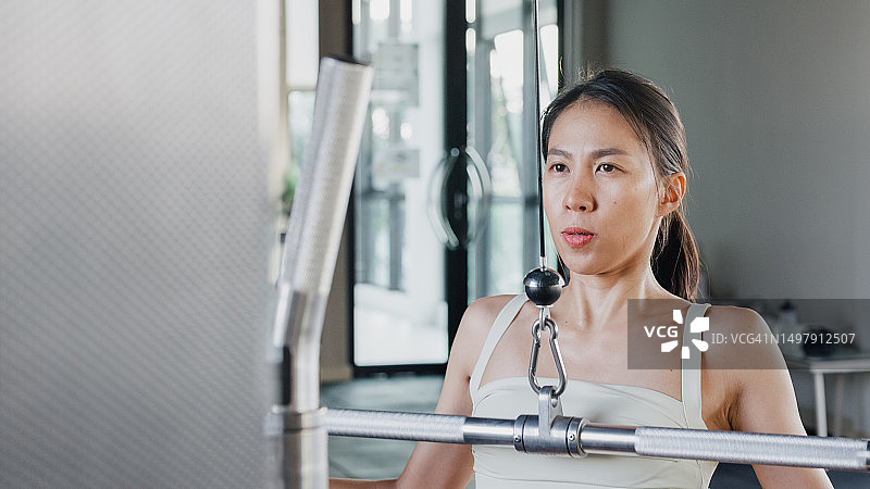 在现代健身房积极锻炼的亚洲女性图片素材