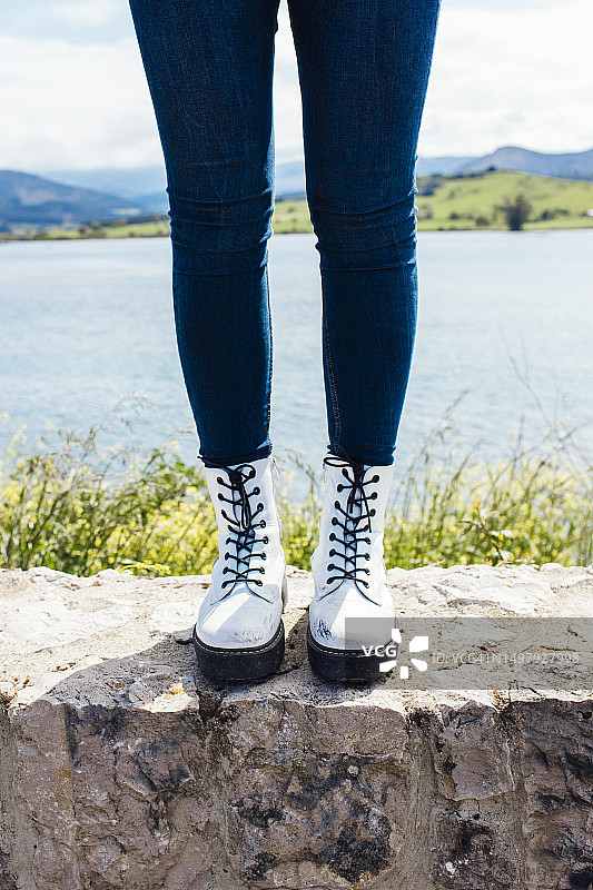 湖中石墙上的白色靴子特写图片素材