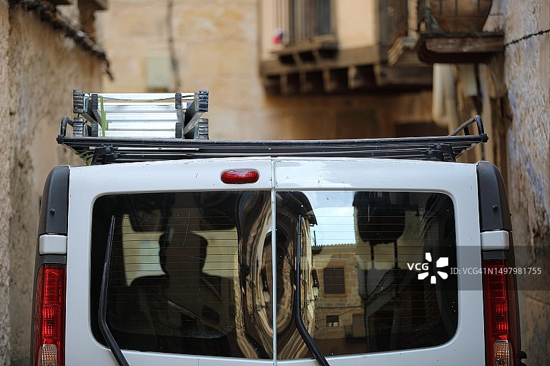 传统村庄狭窄街道上的白色货车图片素材