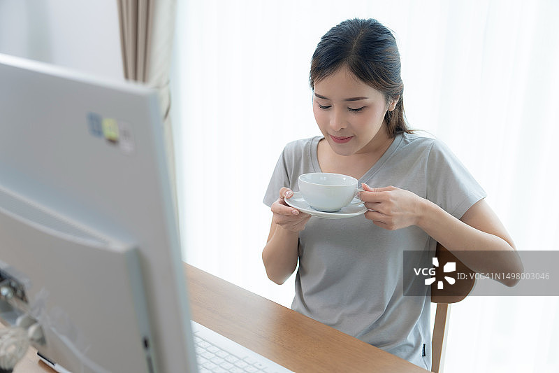 在家通过互联网远程办公的快乐亚洲女性图片素材
