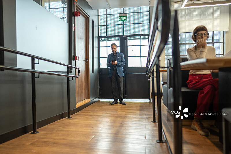 中年商人在办公室使用手机图片素材