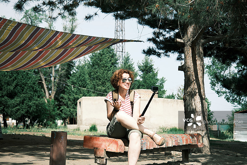 在旧游乐园长椅上直播的女游客图片素材