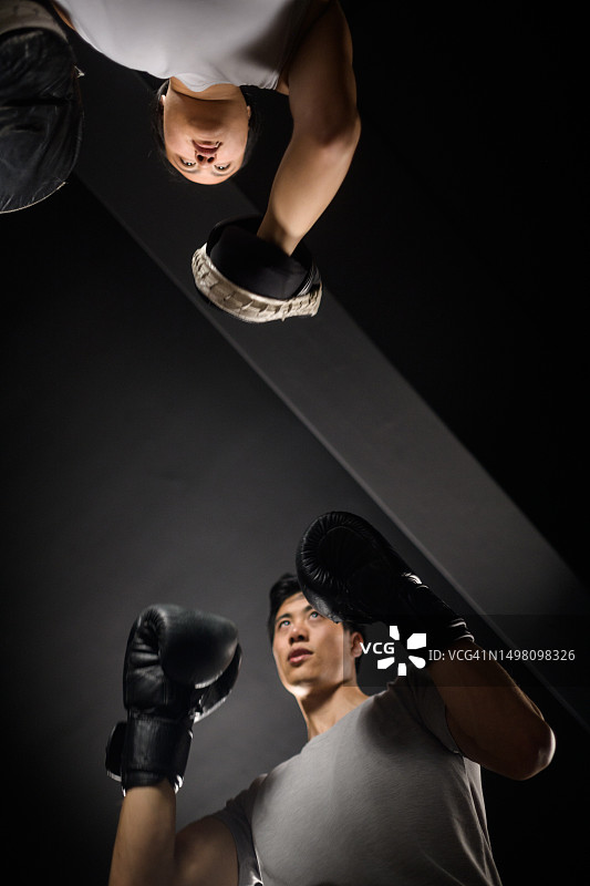 中国男女拳击手勾拳和刺拳击打护垫图片素材