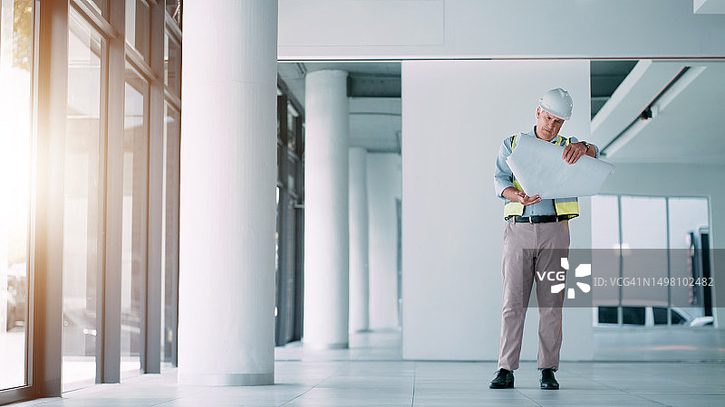 建筑顾问、工业设计师或建筑工人咨询建筑开发平面图设计。建筑师、工程蓝图示意图和项目规划检查员图片素材