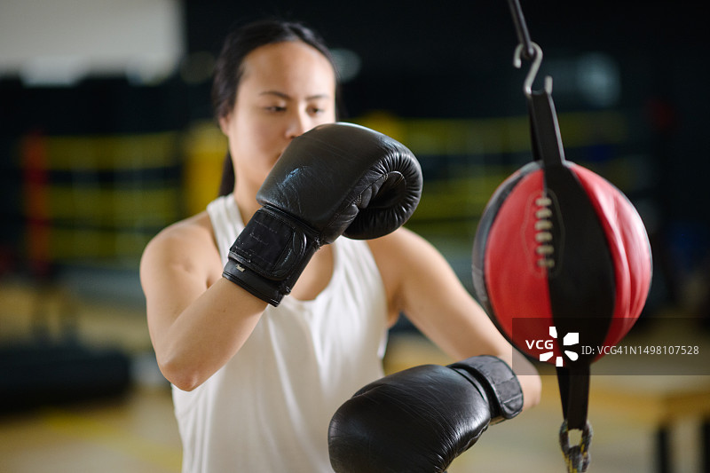 在健身房里用双端球打拳的亚洲女人图片素材
