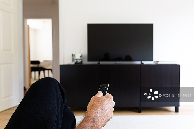 男人用遥控器看电视图片素材