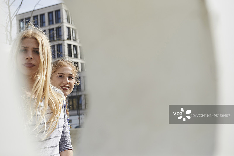 在墙洞中看到的两个朋友，慕尼黑，巴伐利亚，德国图片素材