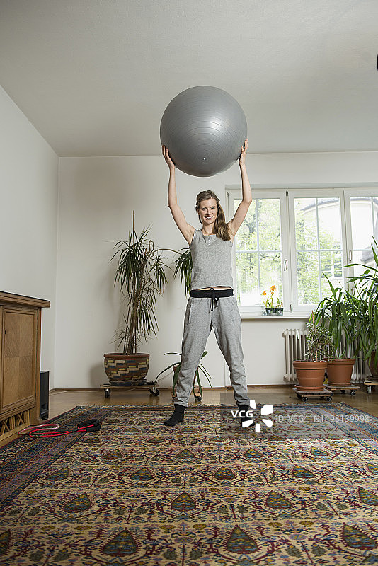 年轻女人在客厅用健身球锻炼 德国慕尼黑图片素材