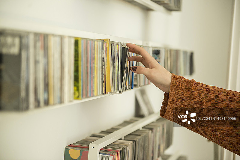 女人从架子上取CD的特写，德国慕尼黑图片素材