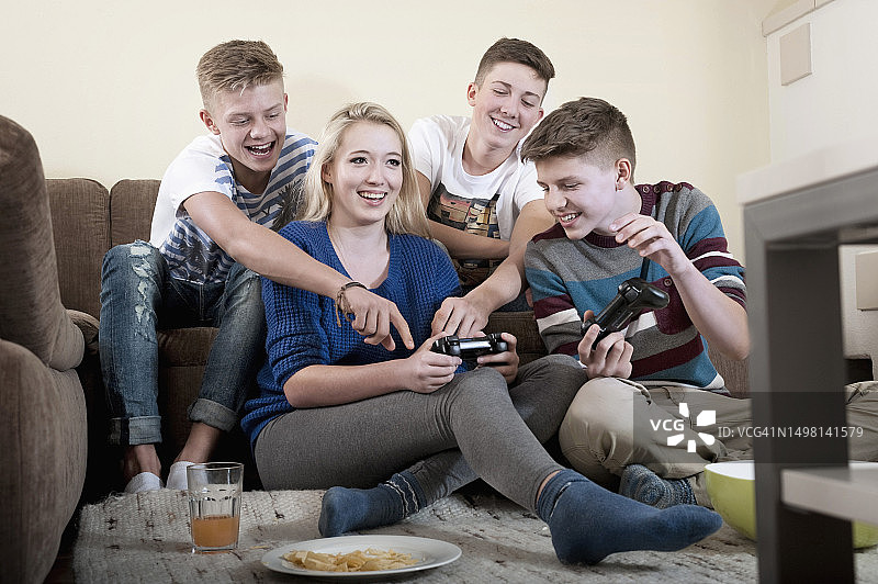 朋友们在客厅里玩电子游戏图片素材