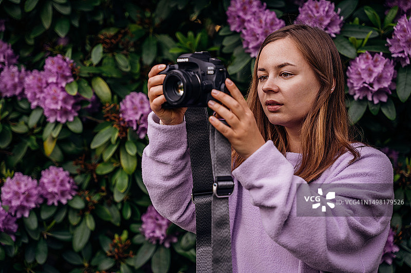 年轻女人用单反相机拍摄自然风光照片图片素材