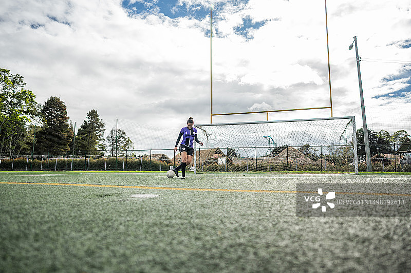 中年妇女在足球场上踢足球图片素材