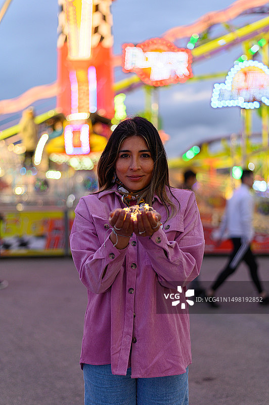 在集市上手持小灯泡的美丽女性图片素材