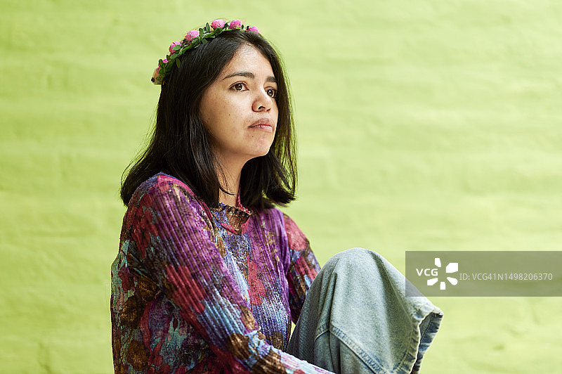 绿色墙前的拉丁裔女人肖像图片素材