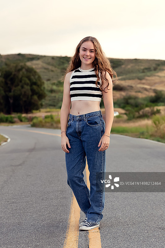 穿着露脐装站在黄线上的少女图片素材