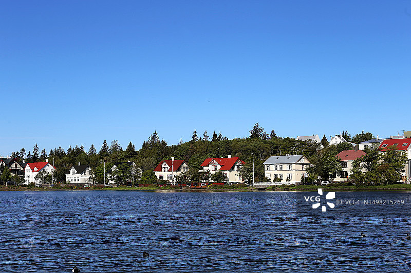 冰岛：湖畔建筑与蔚蓝天空的迷人景色图片素材