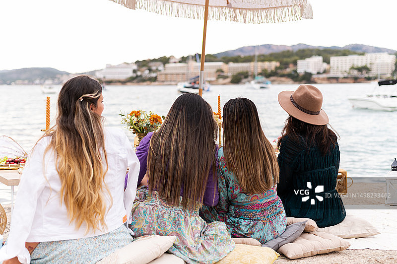女士们坐在海边欣赏海景的背影图片素材
