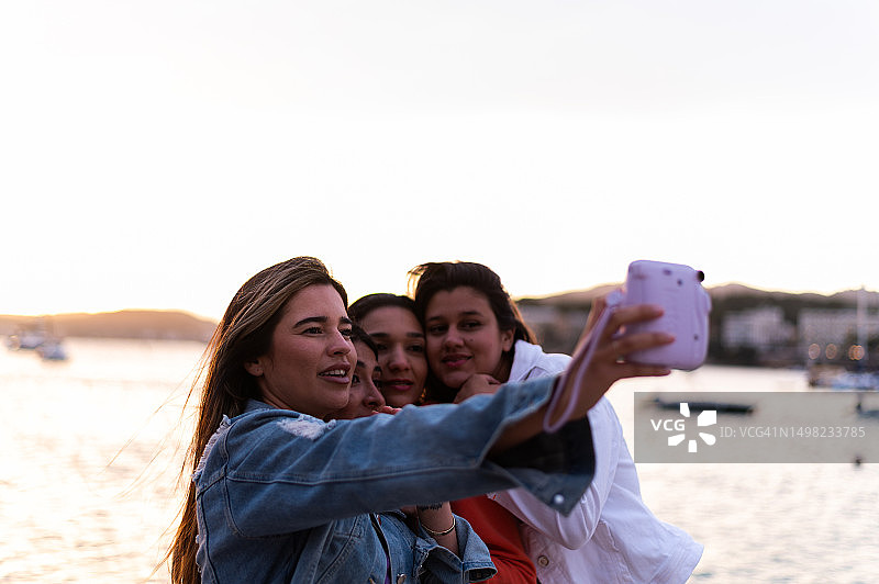 朋友们在日落时分的海洋上自拍图片素材