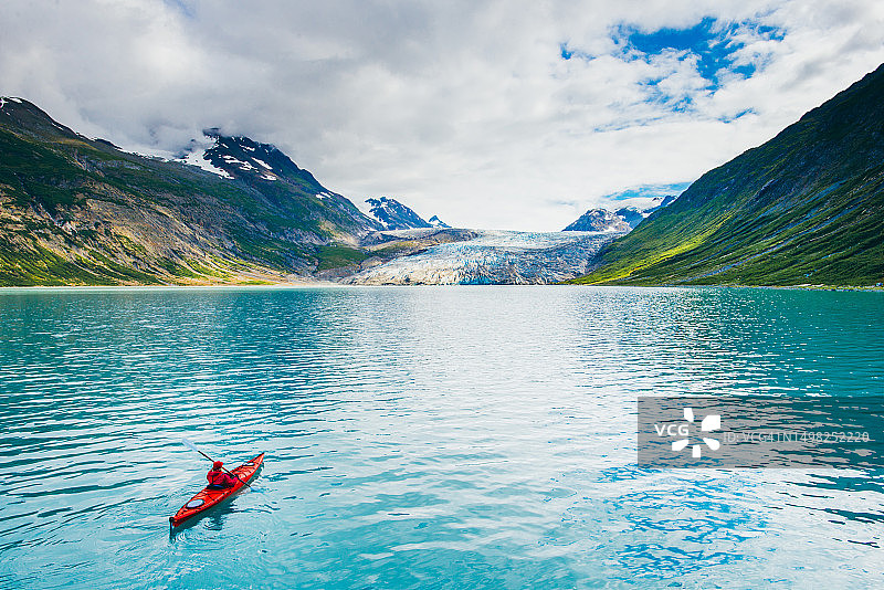 在冰川湾国家公园划皮划艇的女人，背景是冰川图片素材
