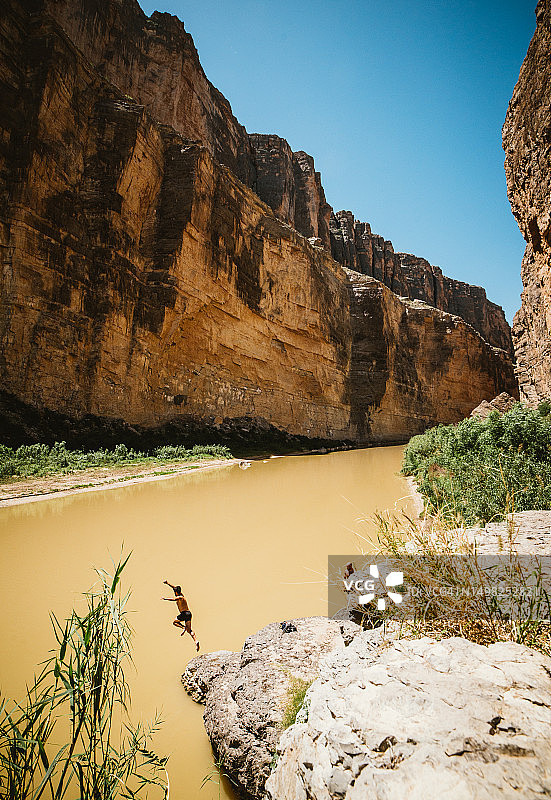 在Big Bend国家公园里，一个人从岩石跳入格兰德河图片素材