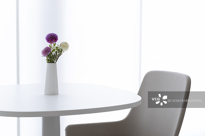 带有花瓶和皮椅的圆桌图片素材
