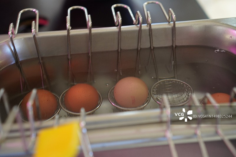 热水锅上的漏勺里的半熟鸡蛋图片素材